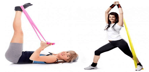 женщина занимается фитнесом с эластичными лентами стоя на платформе